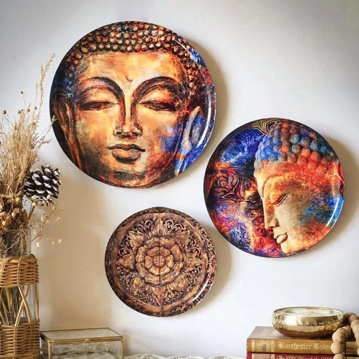 Three Buddha wall plates arranged beside woven and vintage decor.