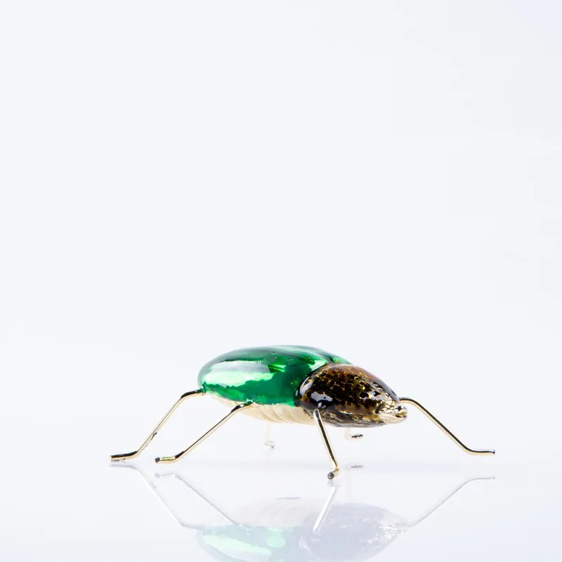 Side view of green and gold dung beetle brass showpiece