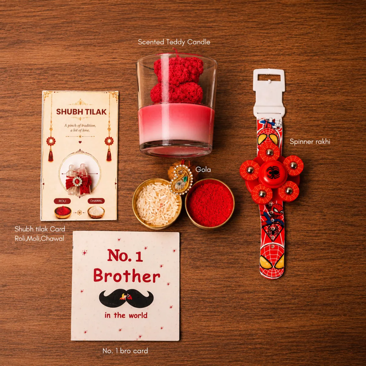 Rakhi hamper components including teddy candle, spinner rakhi, gola and festive cards