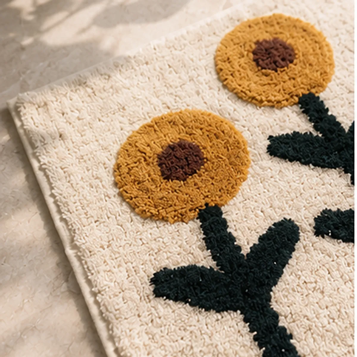 Close-up of yellow floral motifs and soft textured surface on the white bath mat
