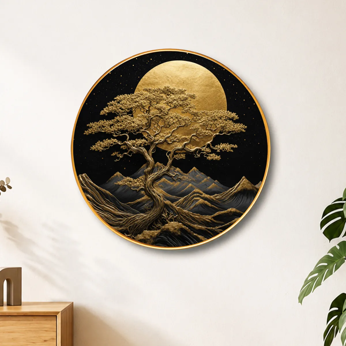 Round black and gold tree wall art mounted on a light wall with plants nearby