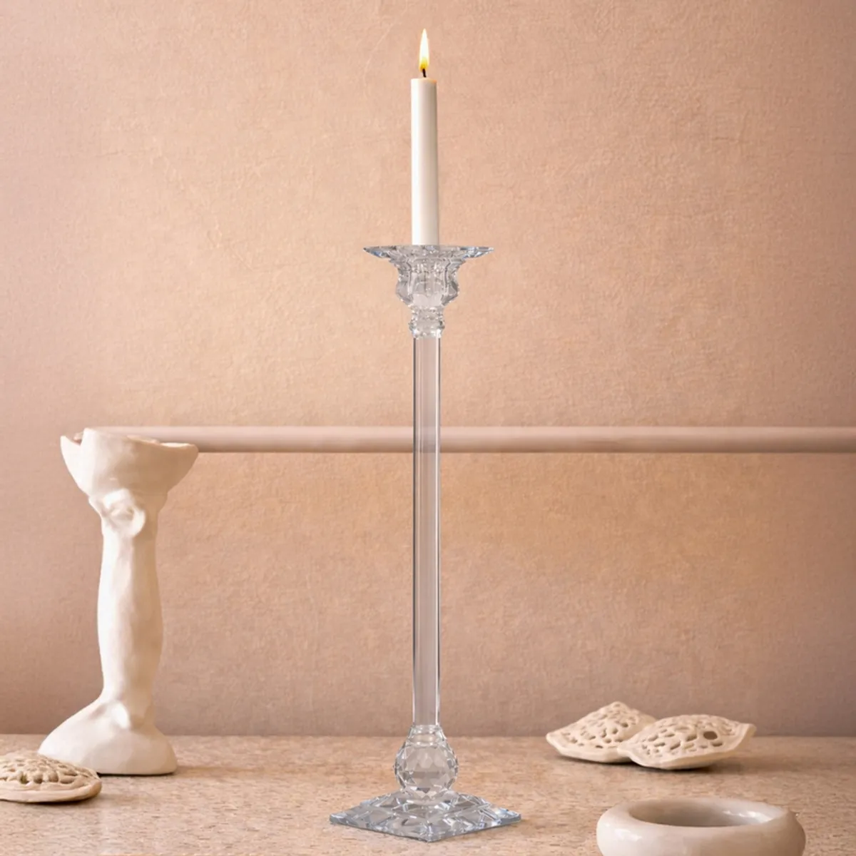 Transparent crystal candle holder styled on a warm-toned console