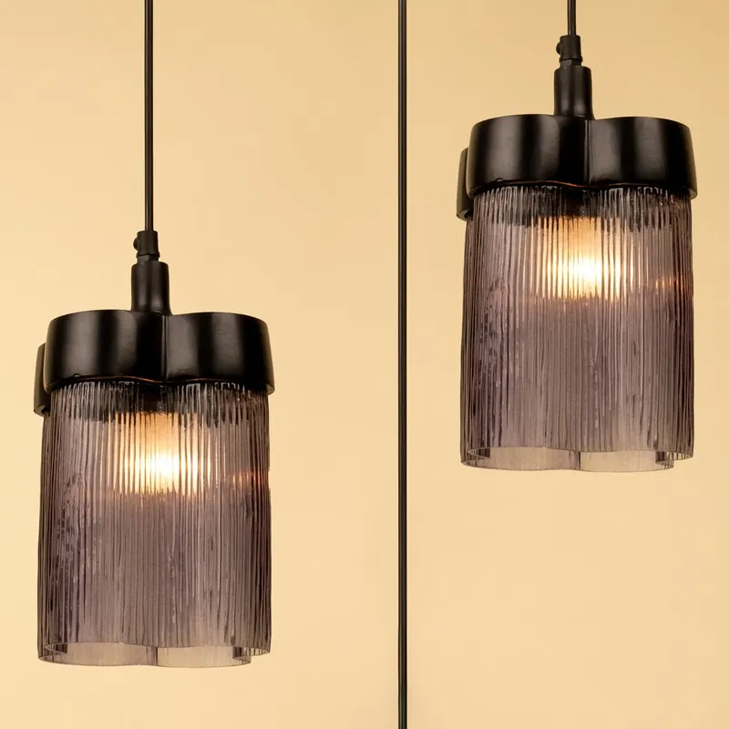 Close-up of two smoky ribbed glass pendant lamps with warm light