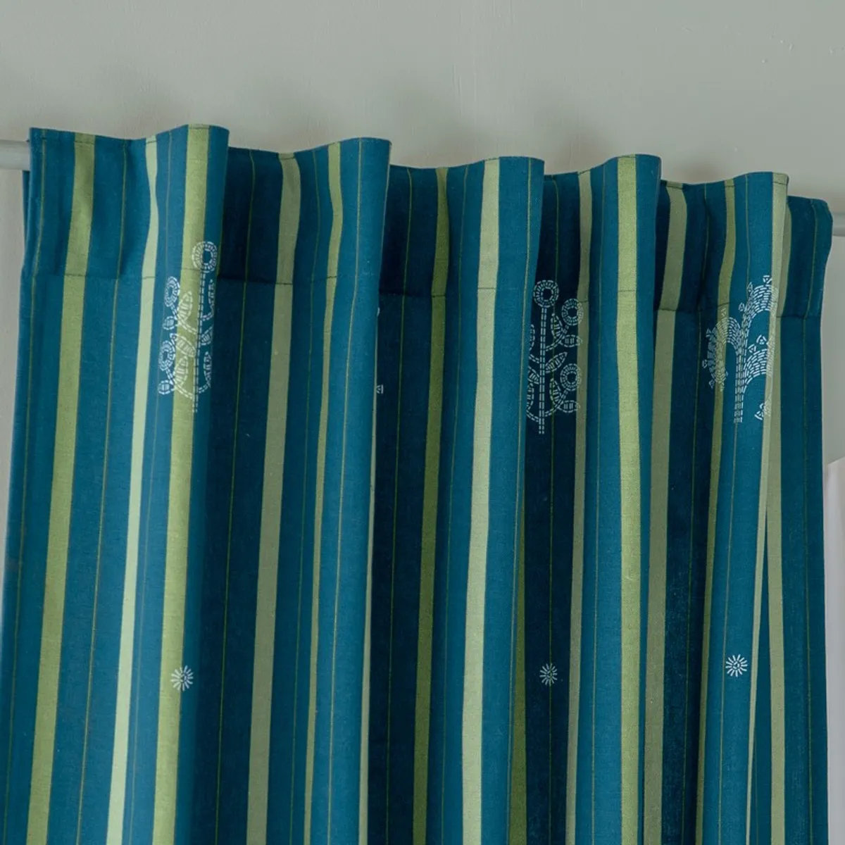 Close view of blue curtain top with back tabs and vertical olive stripes