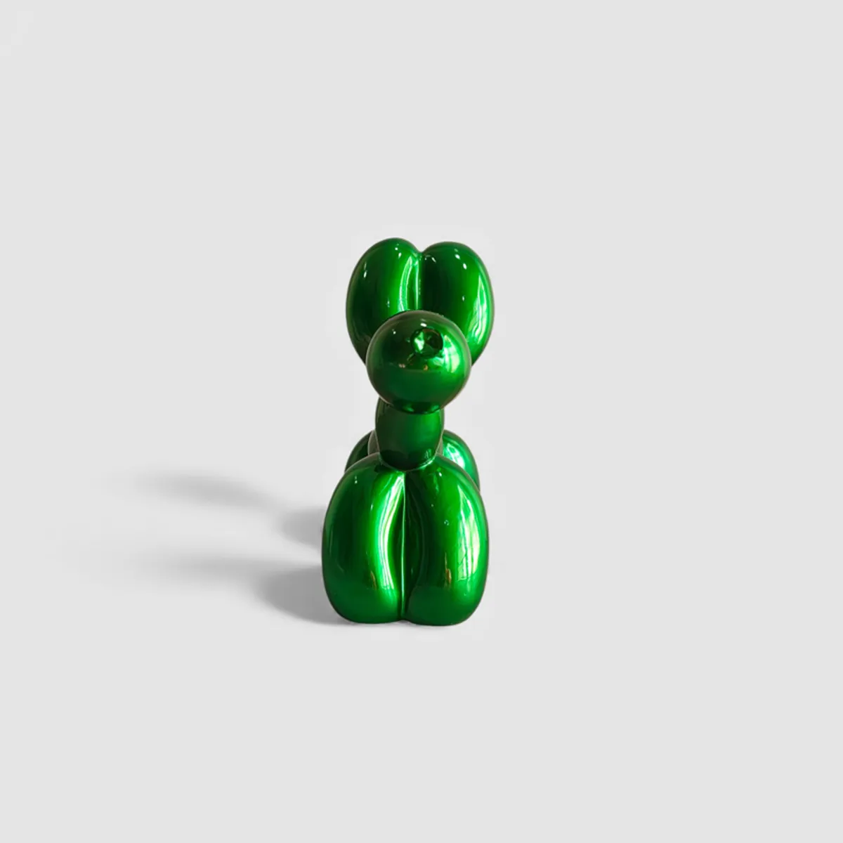 Front view of the glossy green balloon-dog showpiece on a light background.