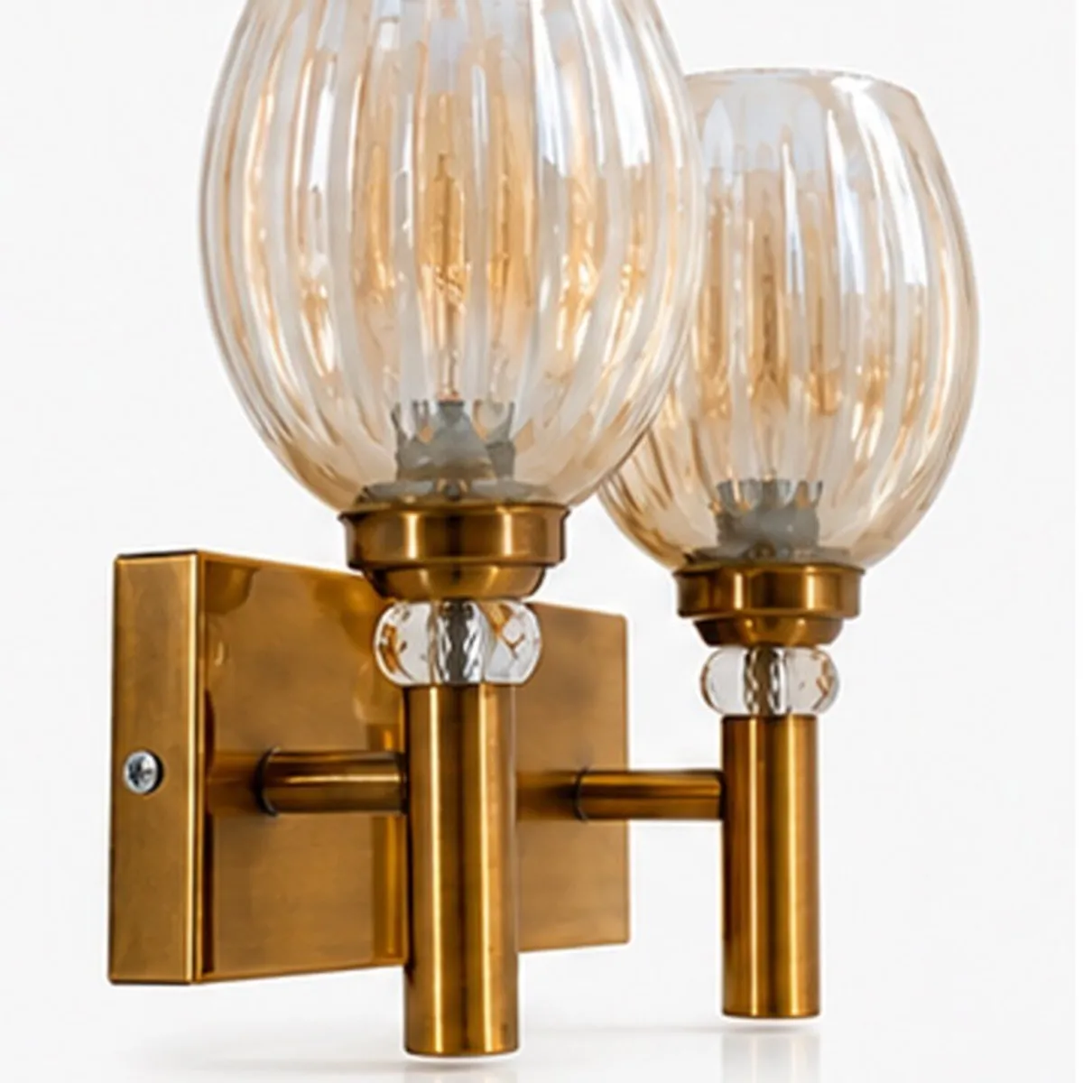 Angled view showing the gold metal wall lamp base and twin glass globes