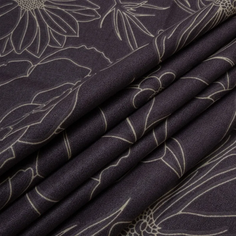 Folded dark purple floral bedsheet fabric showing surface texture