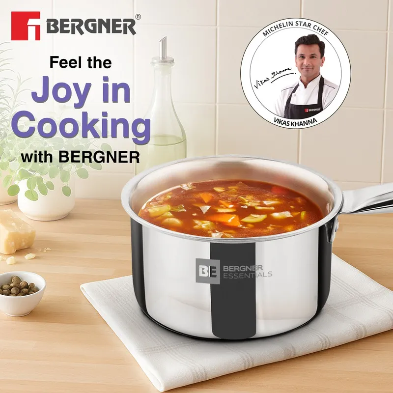 Silver saucepan with a hearty soup styled on a kitchen counter.