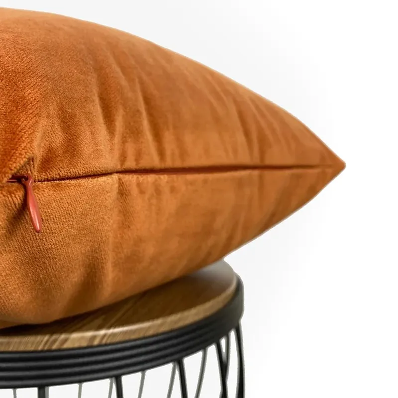 Close-up of rust velvet cushion cover with zipper detail