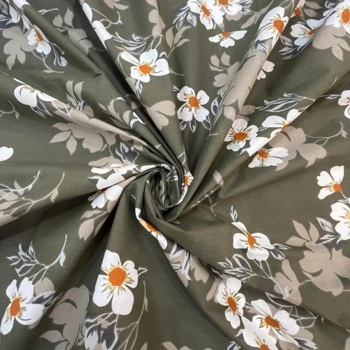 Green floral bedsheet fabric gathered to show its soft drape