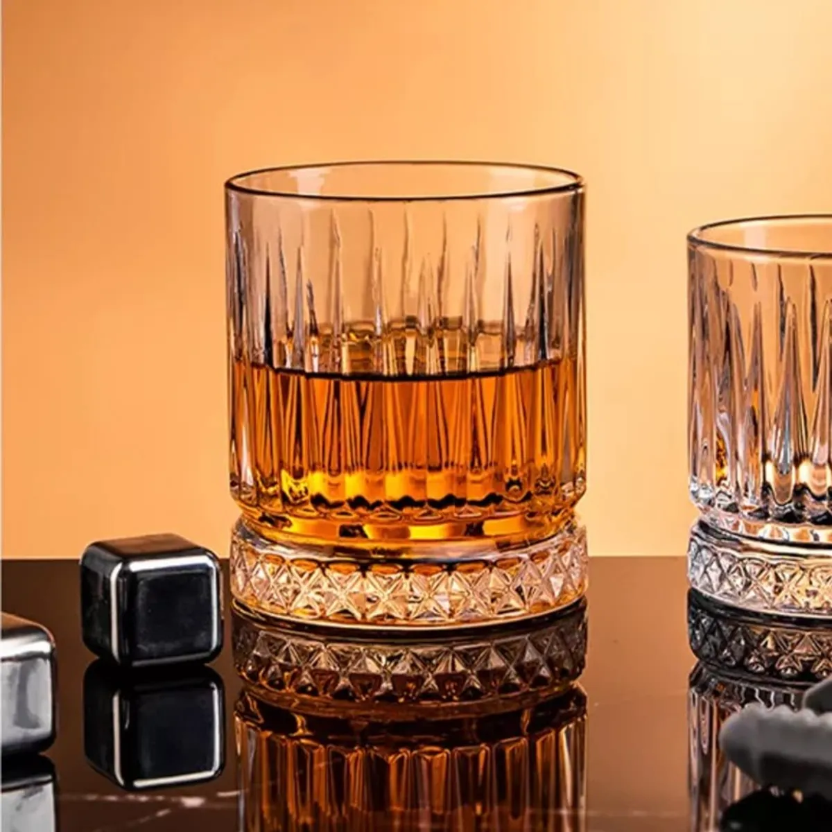 Close-up of a clear textured whiskey glass with amber drink