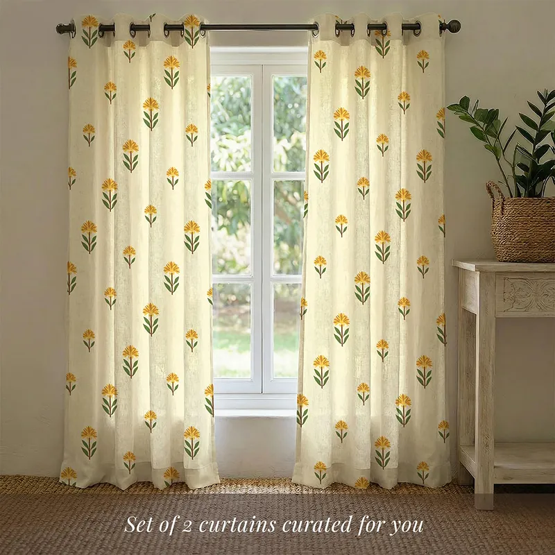 Set of two yellow floral printed ivory curtains on a curtain rod