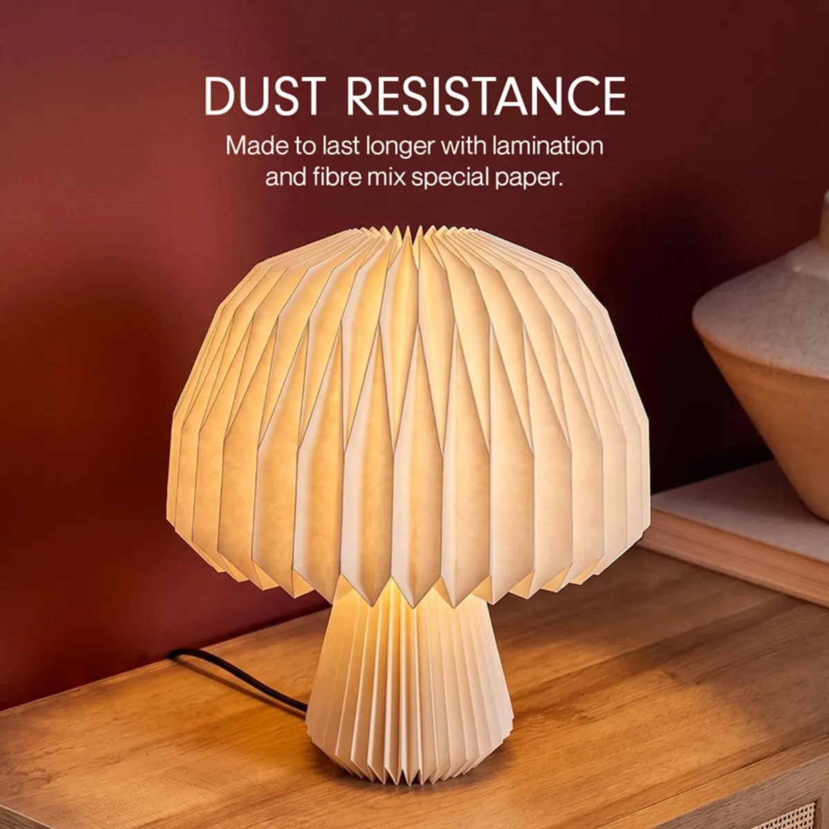 Close-up of the glowing pleated paper shade on a wooden surface