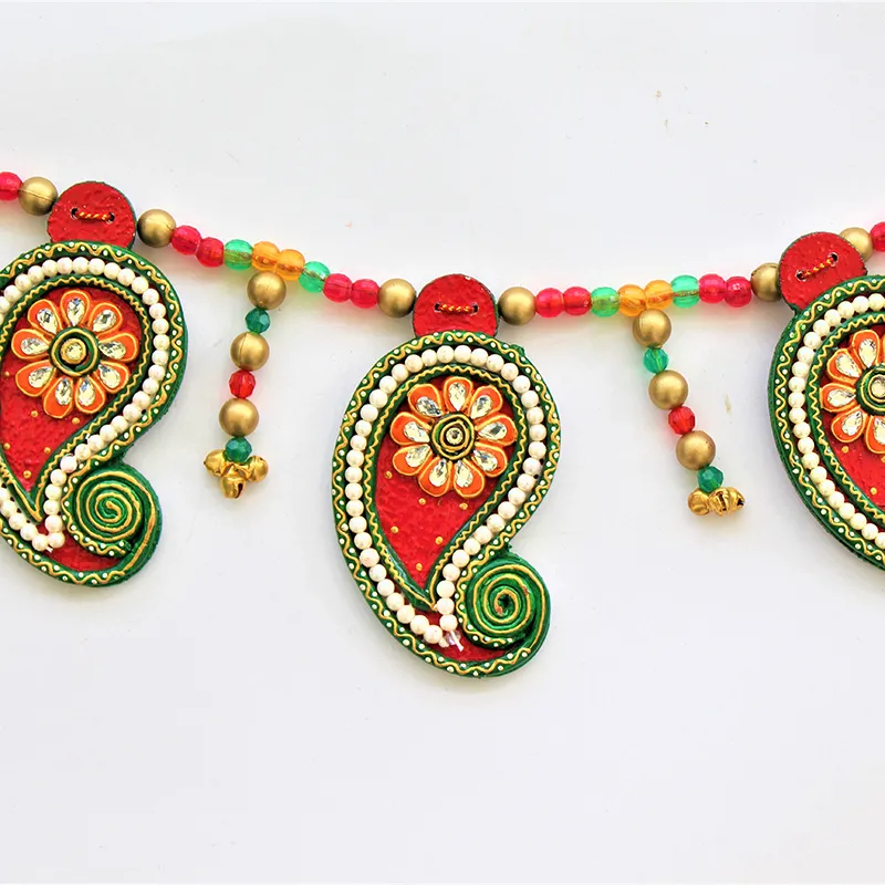 Close-up of red paisley-shaped toran elements with floral detailing and beads