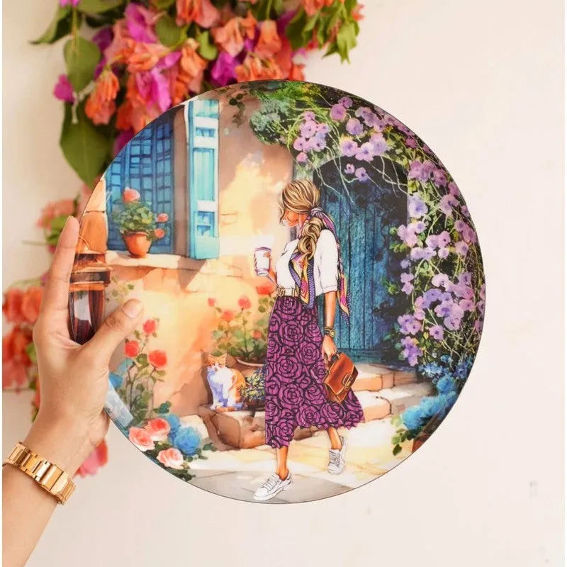 Close-up of a round wall plate showing a woman in a floral courtyard scene.