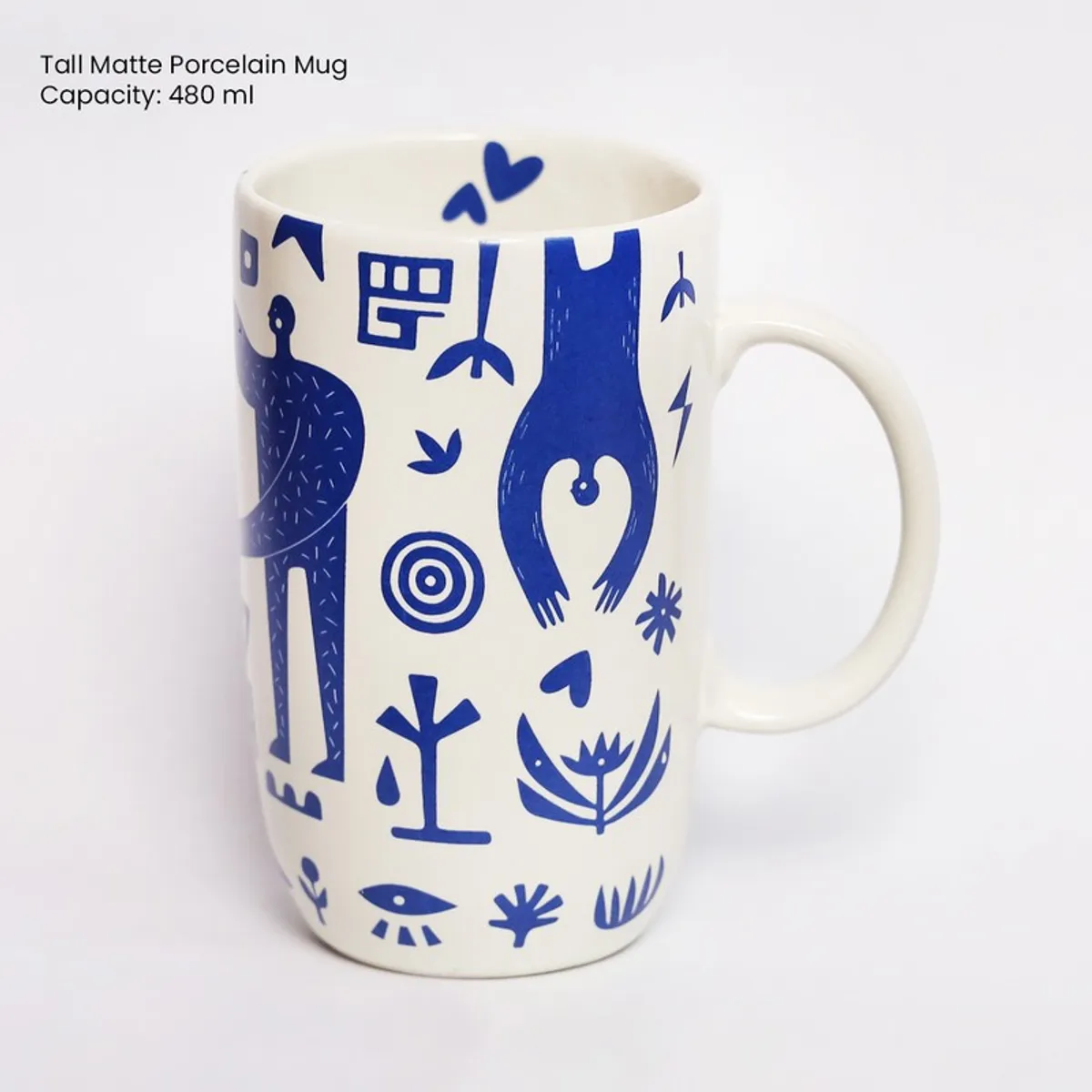 Side view of tall white mug with blue abstract and figurative design