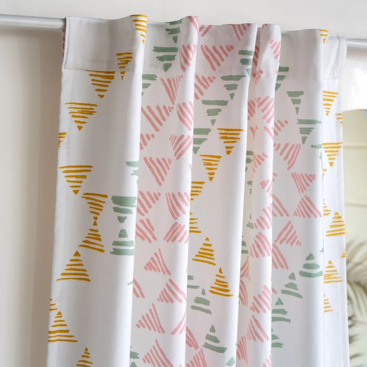 Close-up of back-tab curtain top with colourful geometric print