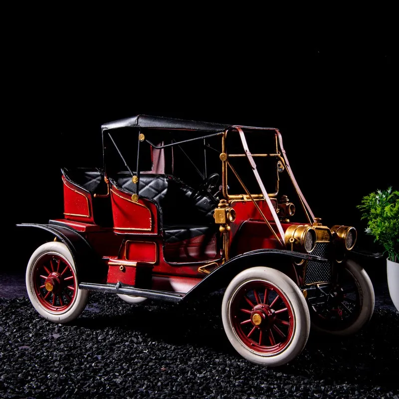 Front angled view of red vintage car iron showpiece against a black background