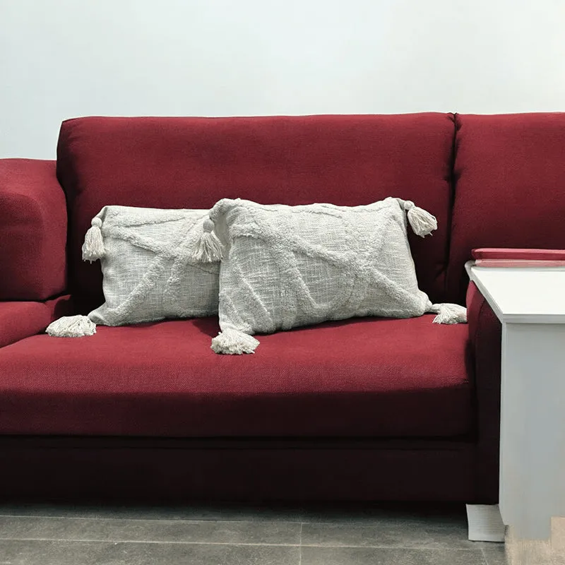 Two grey tufted rectangular cushion covers styled on a red sofa