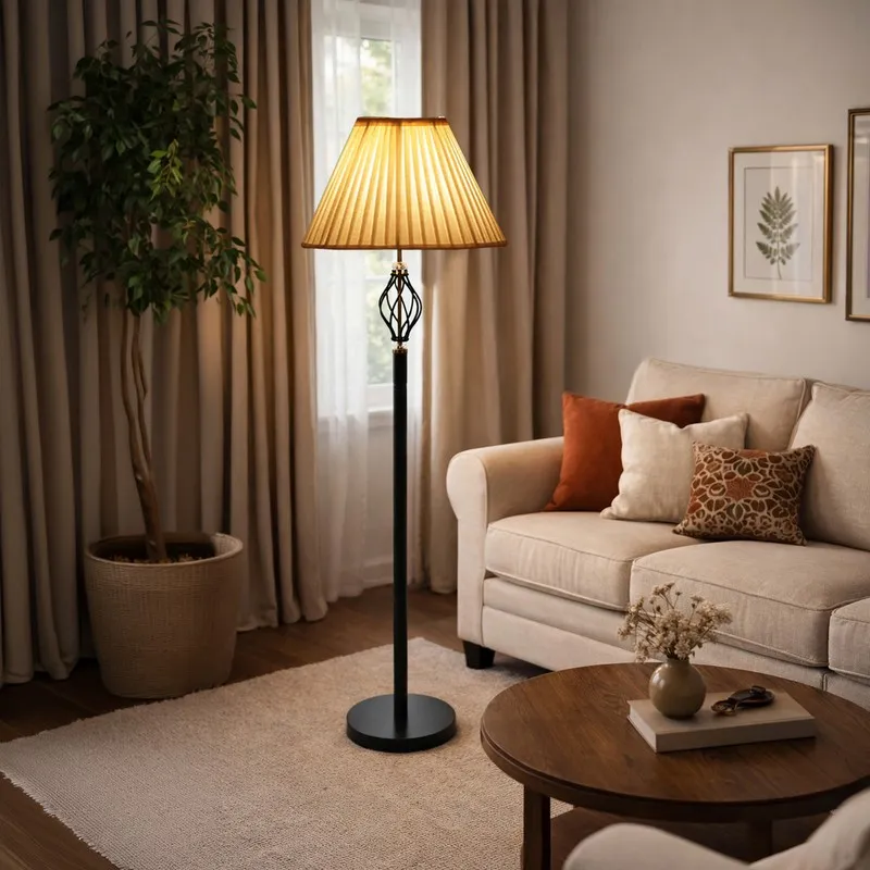 Lit pleated floor lamp next to a cream sofa and curtains in a cosy living room