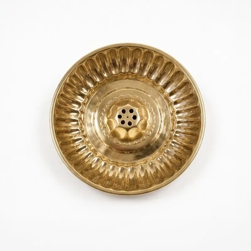 Top view of a round gold-toned brass incense holder