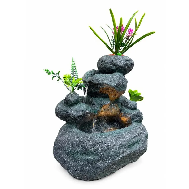 Angled view of a grey rock-style fountain with faux greenery and LEDs