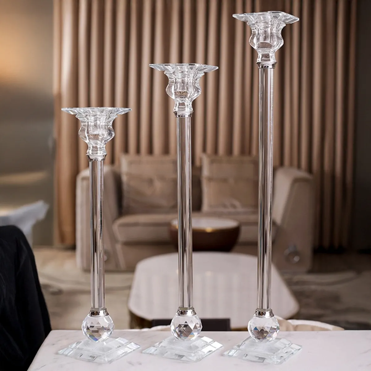 Single tall transparent crystal candle holder on a white background