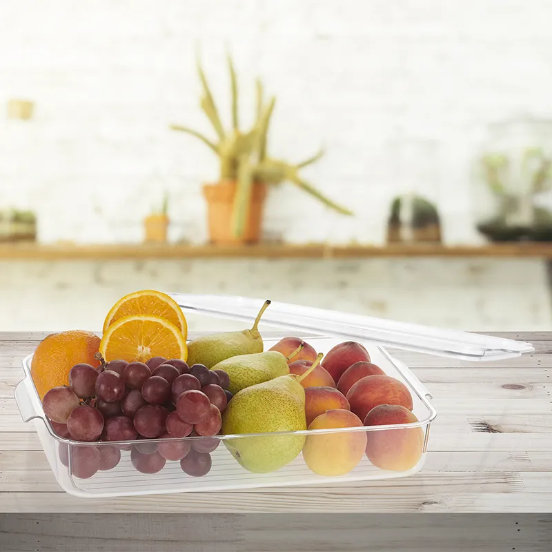 Clear organiser filled with assorted fruit on a rustic wooden table