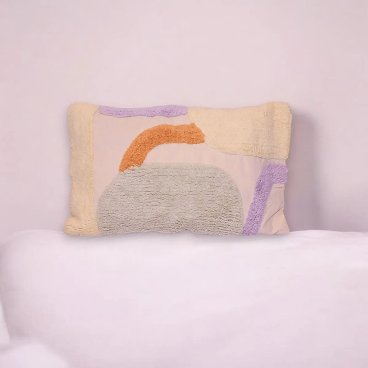 Rectangular beige tufted cushion cover with abstract orange and lilac accents