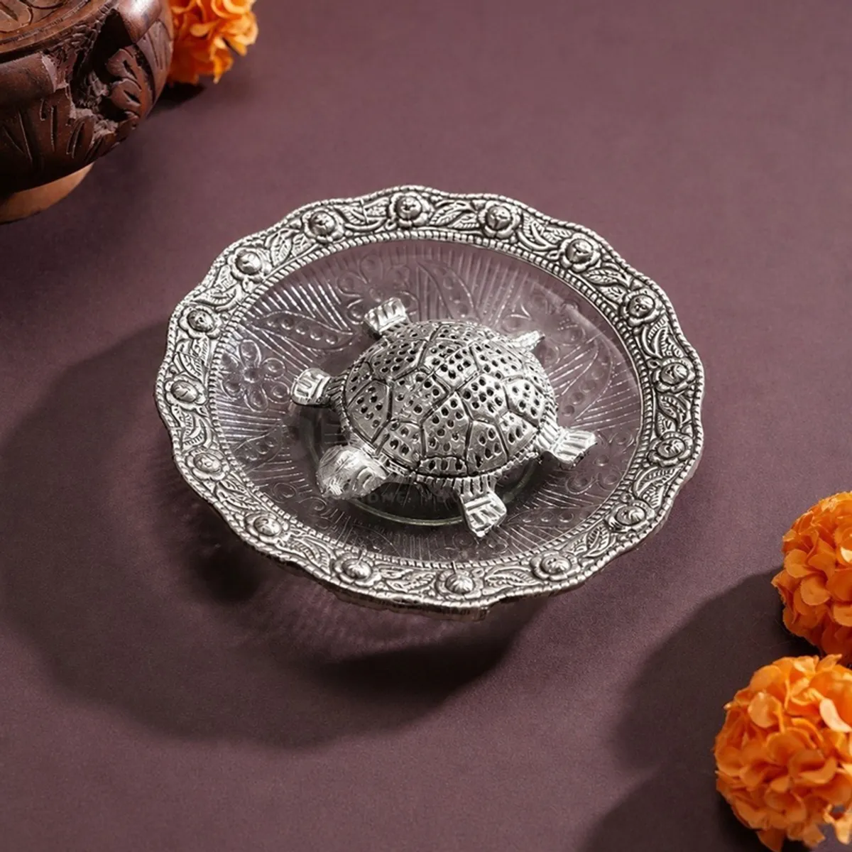 Ornate silver turtle décor placed on a round decorative plate