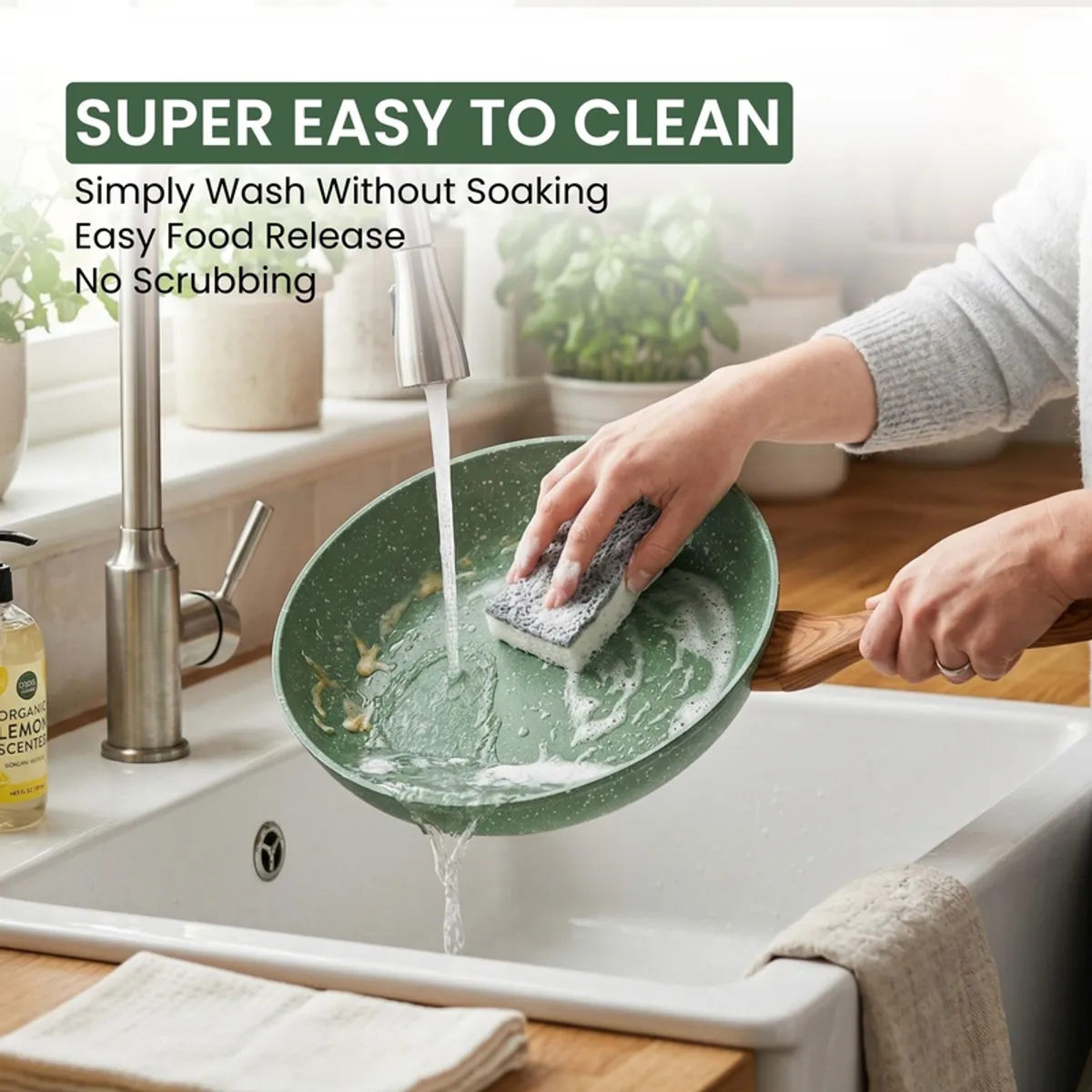 Green frying pan being washed under running water in a sink