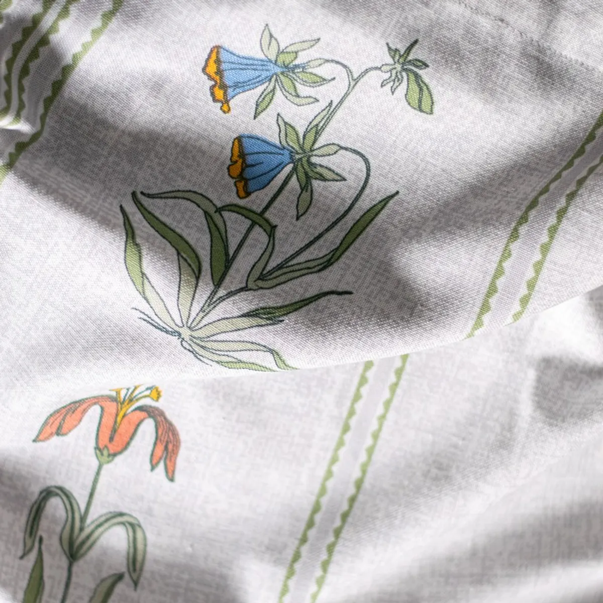 Close-up of blue and orange floral print on white curtain fabric