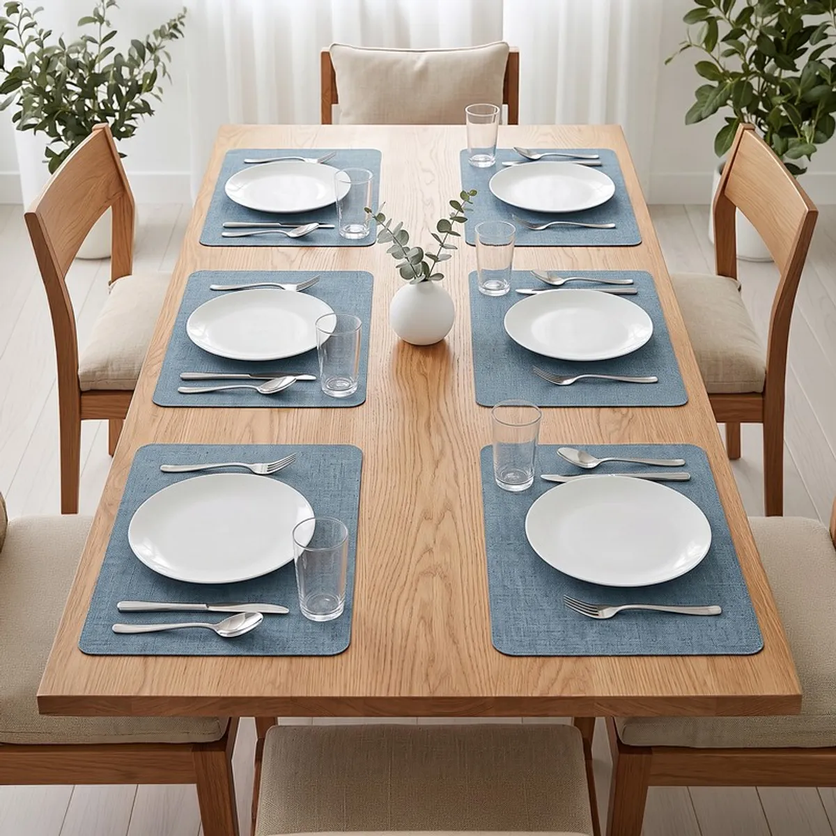 Dining table set with six blue rectangular table mats and white plates