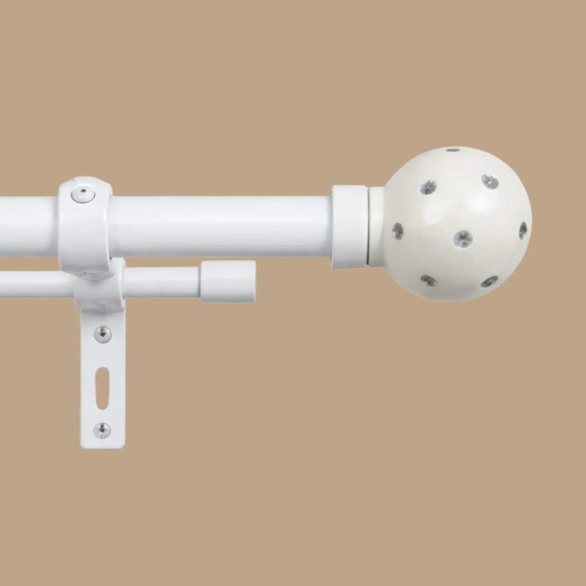 Close-up of white double curtain rod with round polka-dot finial and bracket