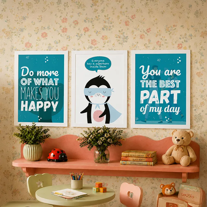 Three framed blue nursery-style prints above a shelf with plants, books and a teddy bear.