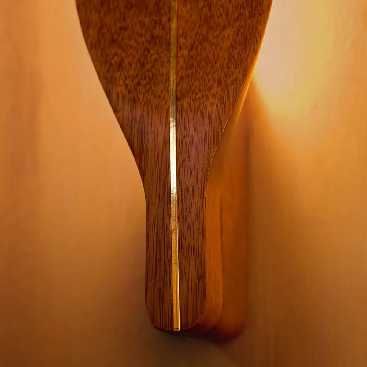 Close-up of the lower section of the brown wall lamp with illuminated centre line