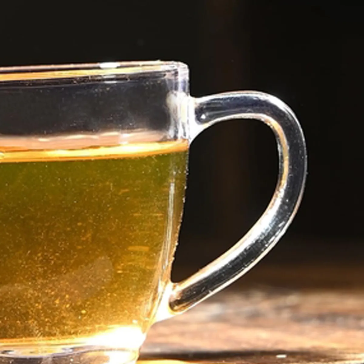 Close-up of the transparent glass cup handle and tea inside.