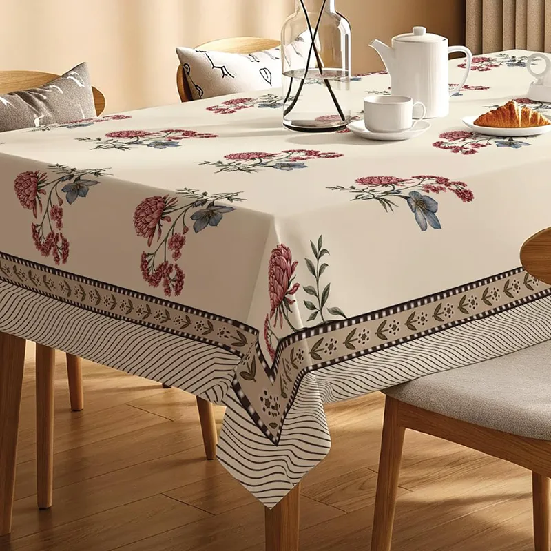 White rectangular table cover with maroon floral print and striped border on a dining table