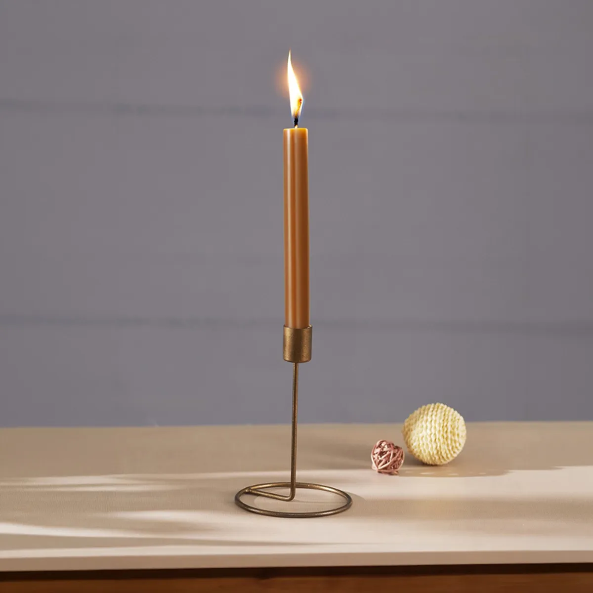 Single brown tealight holder with a lit candle on a tabletop