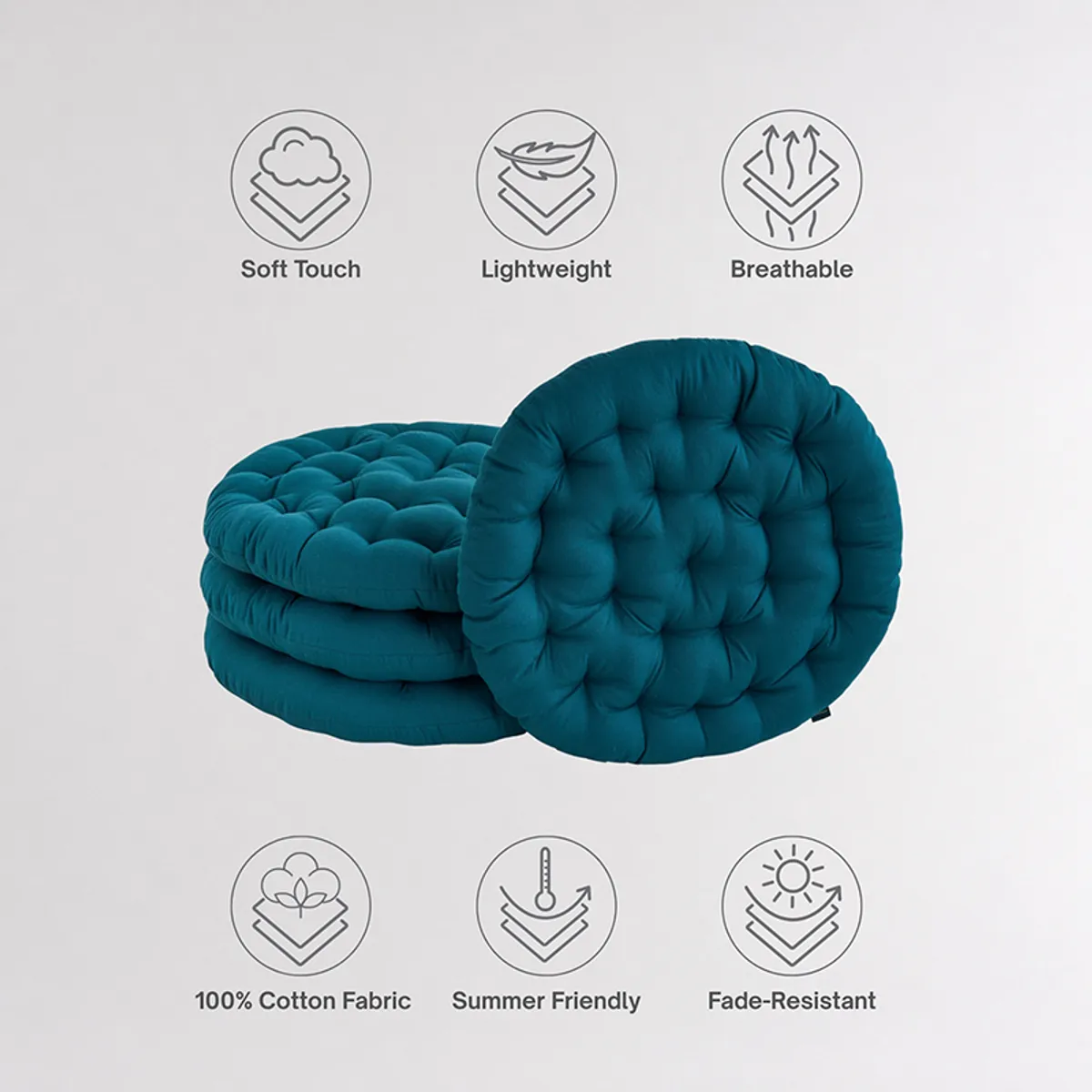 Stack of round deep green tufted floor cushions with one cushion standing upright