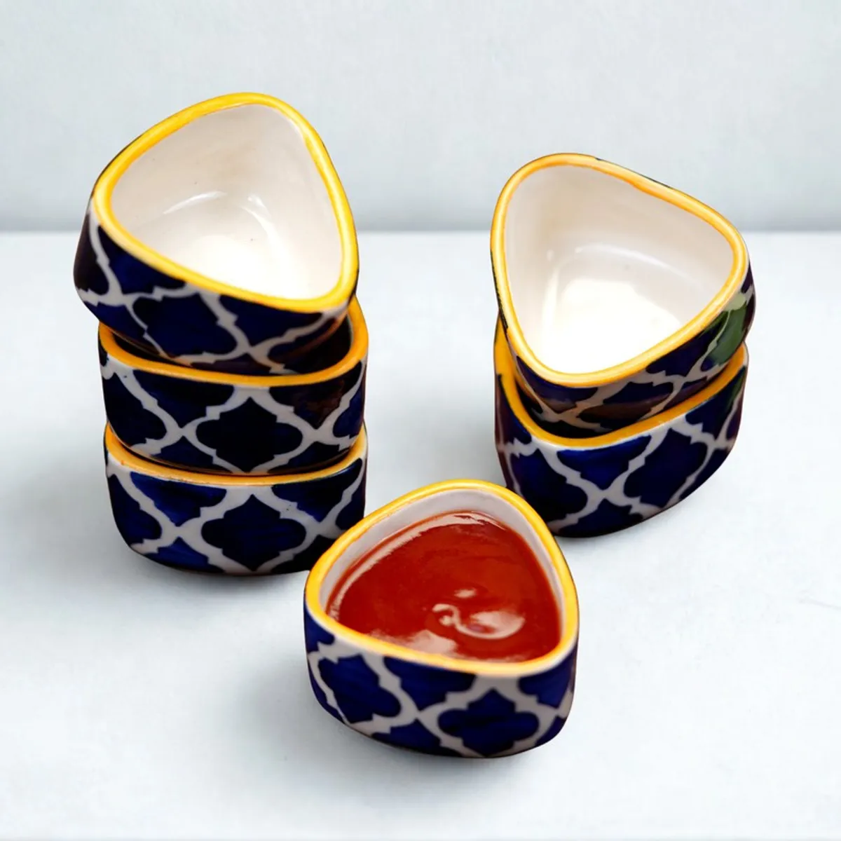 Blue and white patterned ceramic dip bowls with yellow rim