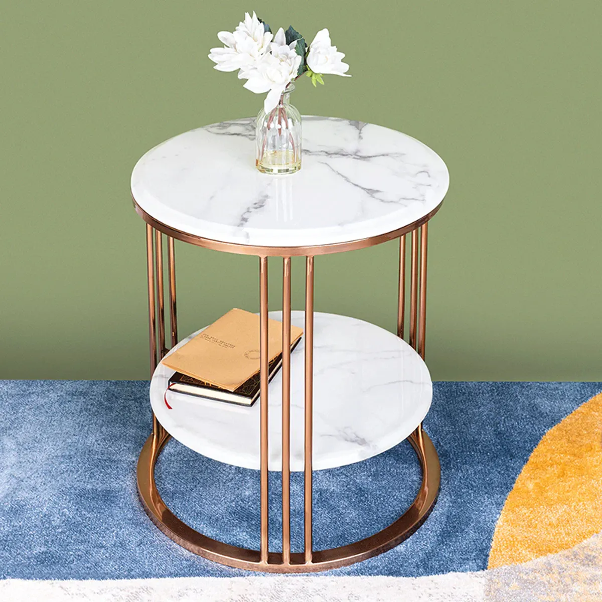 White and gold round side table with two marble shelves against a green wall
