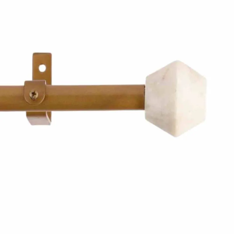 Close-up of gold curtain rod bracket and white marble-look hex finial