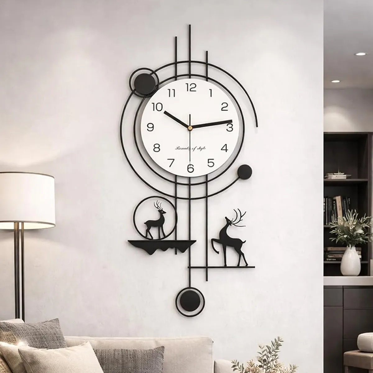 Large black metal wall clock with white dial displayed above a sofa