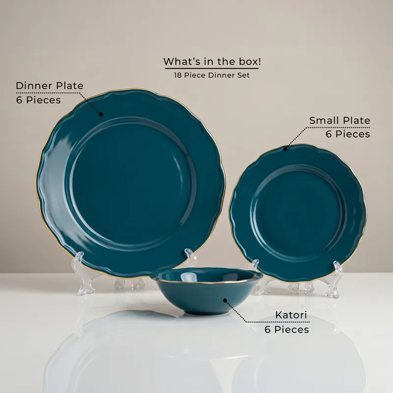 Dark teal dinner plate, small plate and bowl with gold rims displayed together.