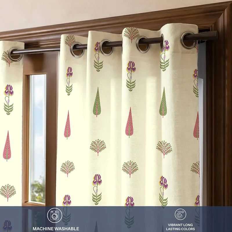 Close-up of printed off-white curtain with eyelets on a wooden rod