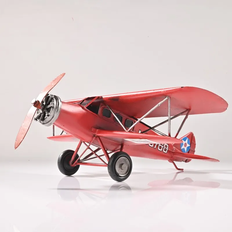 Side view of the red vintage aeroplane showpiece on a white background
