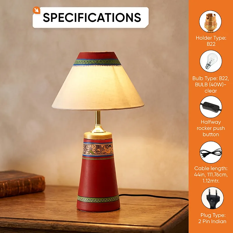 Red terracotta table lamp with cream shade on a wooden tabletop