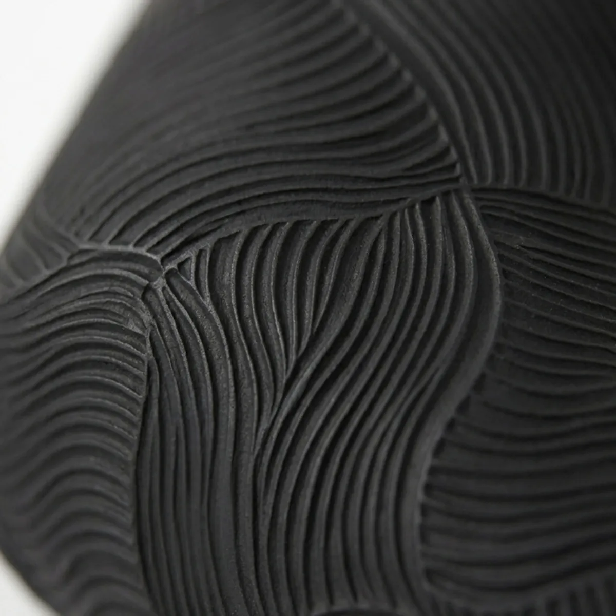 Close-up of the dispenser's raised flowing wave texture in black