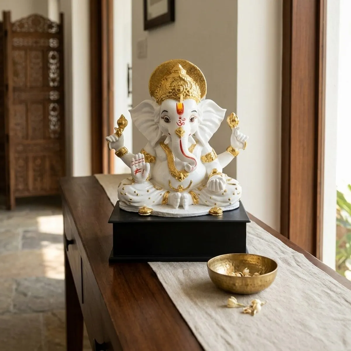 White and gold Ganesha idol styled on a wooden console in an Indian home